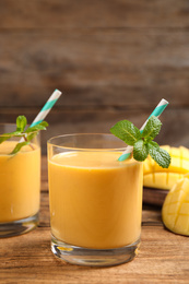 Fresh delicious mango drink on wooden table