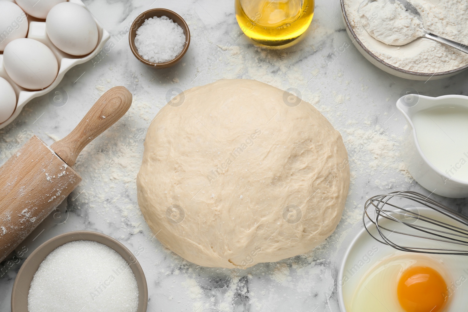 Photo of Fresh yeast dough and ingredients on white marble table, flat lay