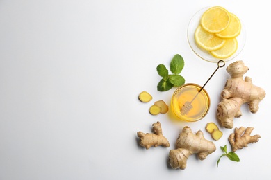 Photo of Ginger and other natural cold remedies on white table, flat lay. Space for text