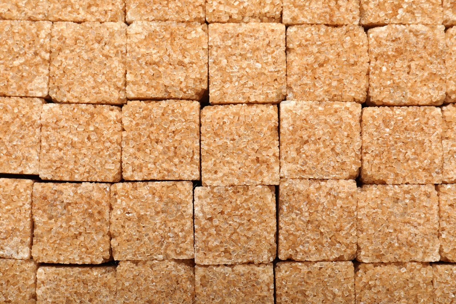 Photo of Brown sugar cubes as background, top view