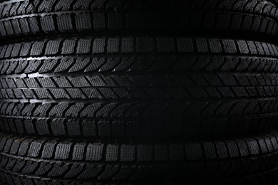 Stacked winter tires as background, closeup. Car maintenance