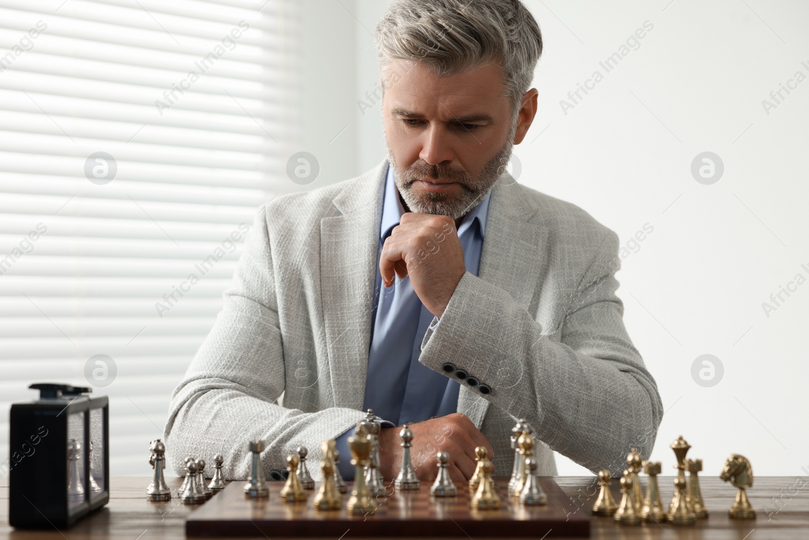 Photo of Man playing chess during tournament at table indoors