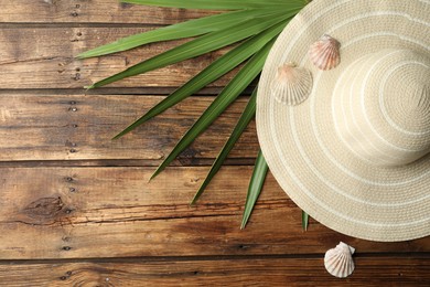 Flat lay composition with hat on wooden background, space for text. Beach objects