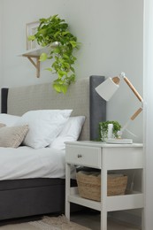 Photo of Stylish bedroom interior with large comfortable bed and bedside table