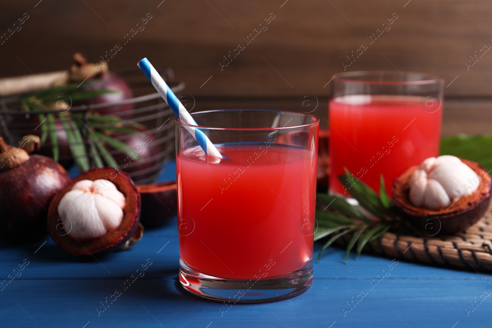 Photo of Delicious fresh mangosteen juice on blue wooden table