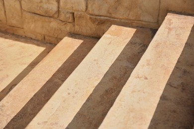 Photo of Closeup view of beautiful stone stairs near brick wall outdoors