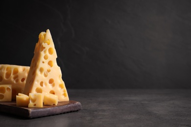 Tasty fresh cheese on dark grey table, space for text