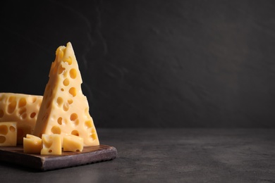 Photo of Tasty fresh cheese on dark grey table, space for text