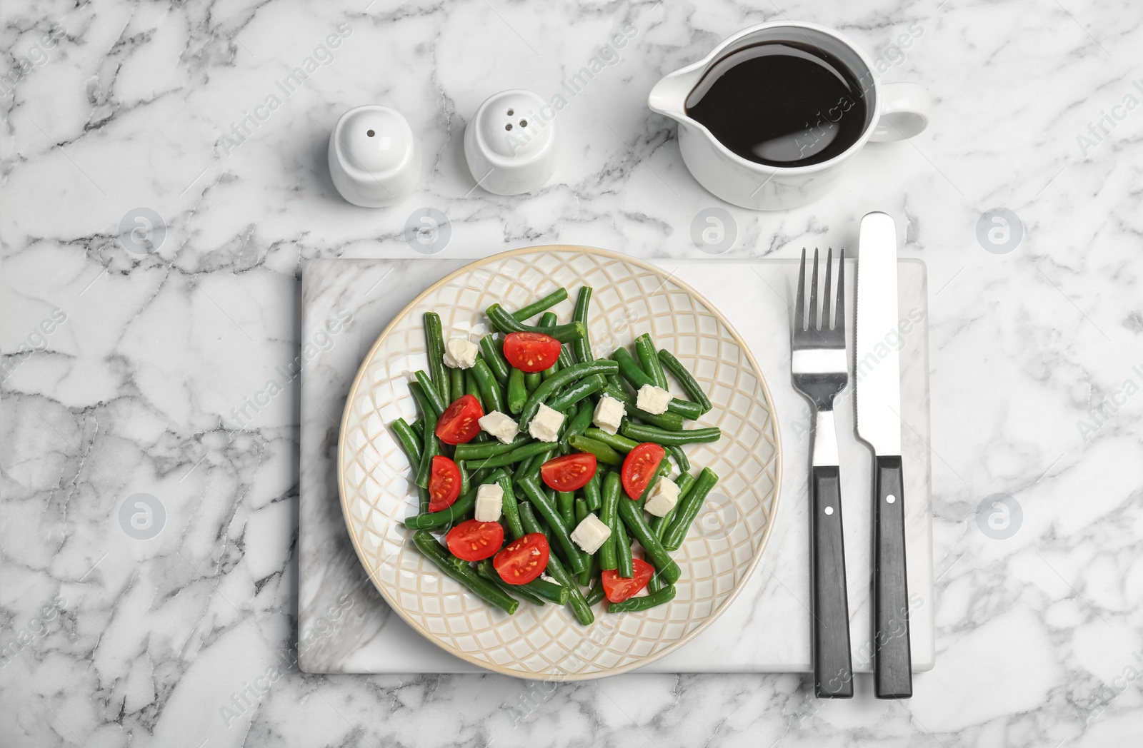 Photo of Tasty green beans with cheese and tomatoes served for dinner on marble table, top view