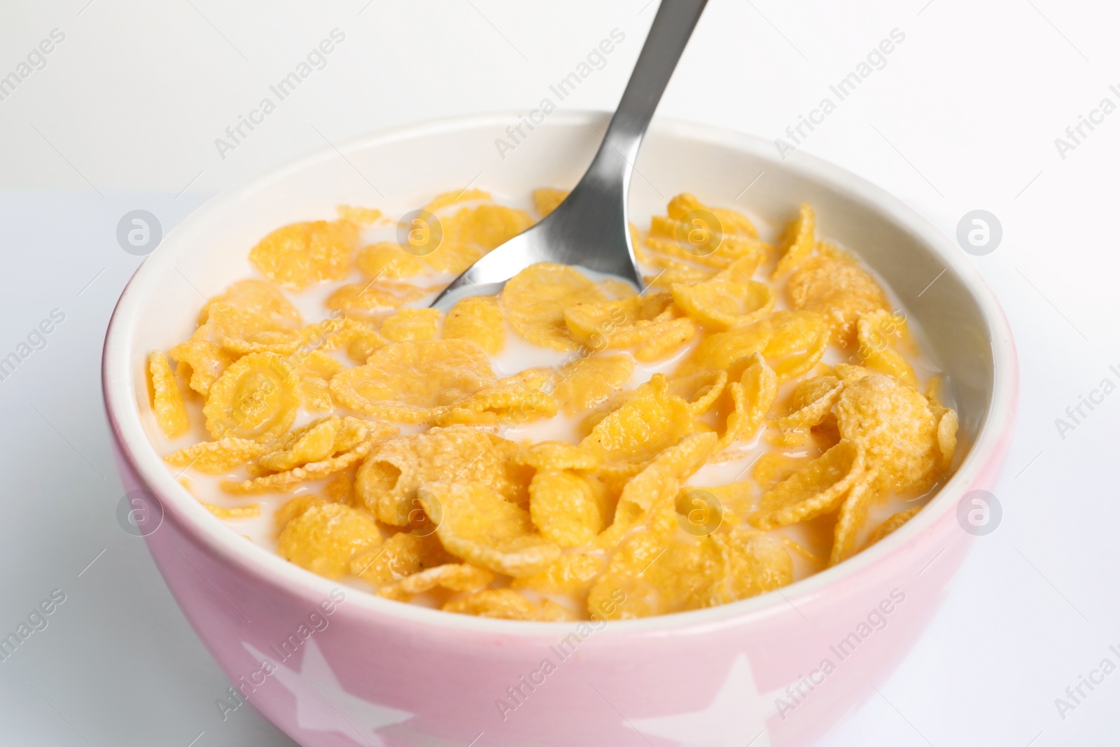 Photo of Bowl with crispy cornflakes on white background