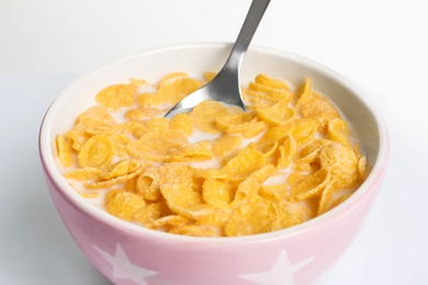 Photo of Bowl with crispy cornflakes on white background