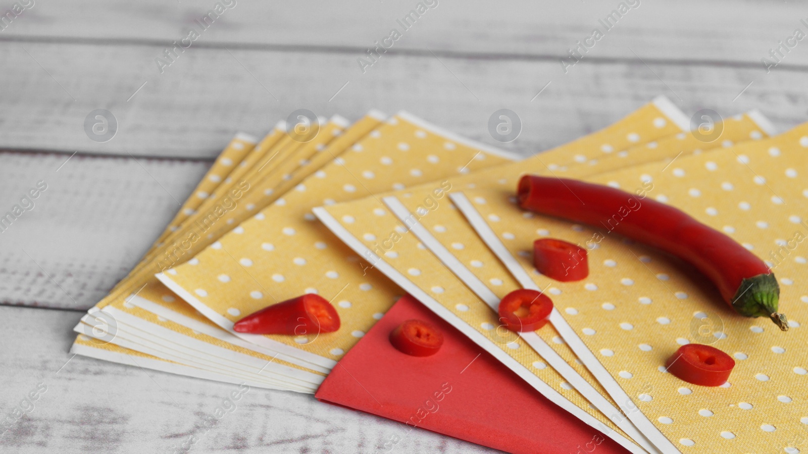 Photo of Many pepper plasters and chili on white wooden table, closeup