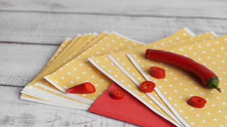 Many pepper plasters and chili on white wooden table, closeup