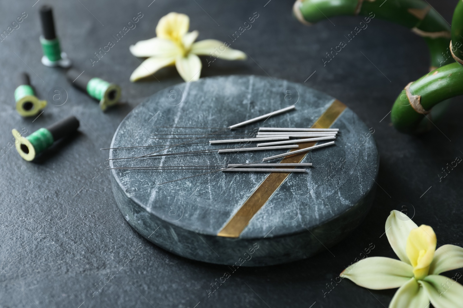 Photo of Composition with acupuncture needles on black table