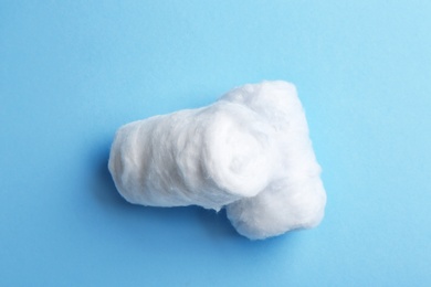 Clean cotton rolls on blue background, top view