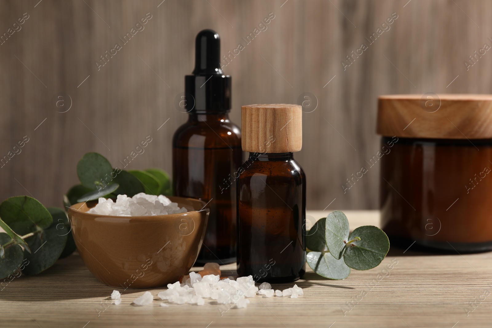 Photo of Composition with spa products and eucalyptus leaves on wooden table