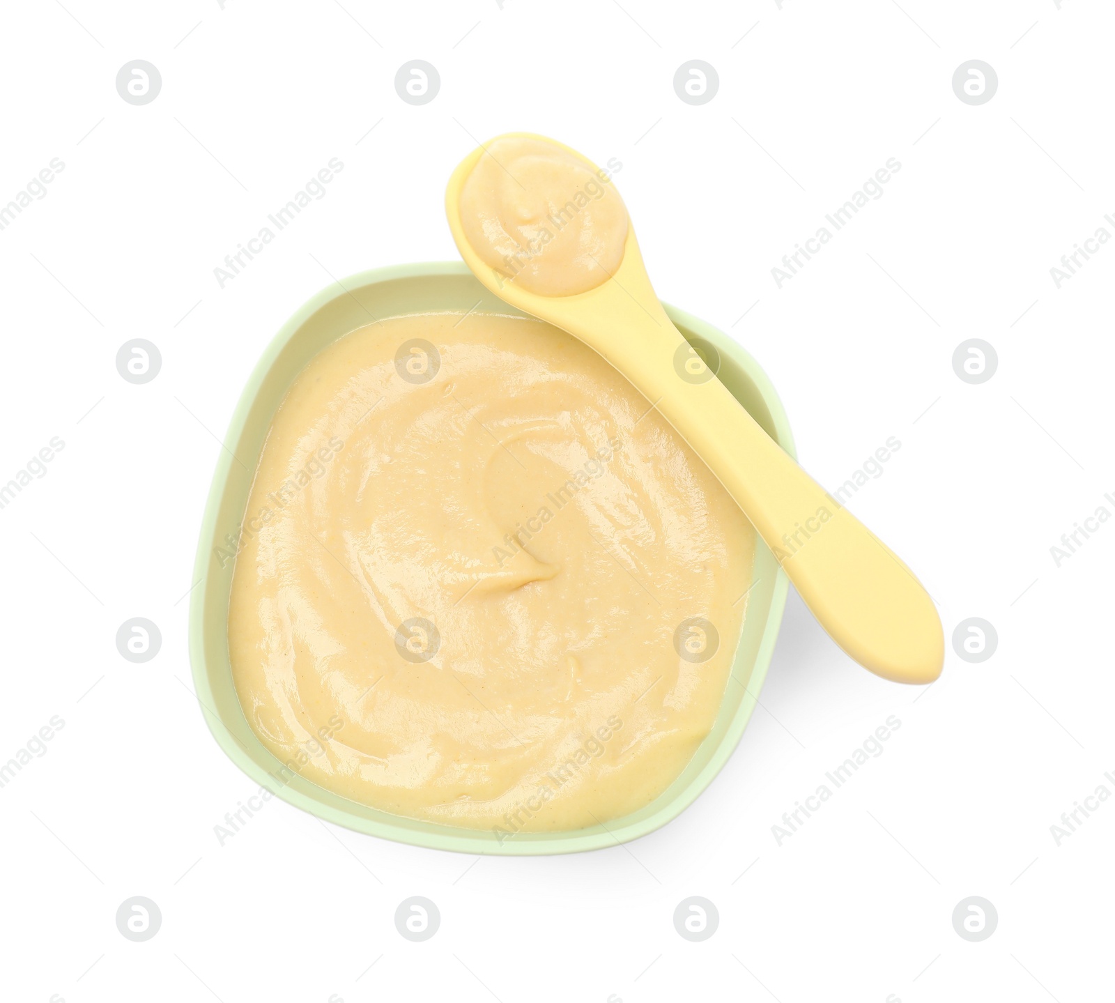 Photo of Tasty baby food in bowl and spoon isolated on white, top view