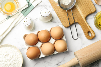 Photo of Flat lay composition with chicken eggs on white marble table