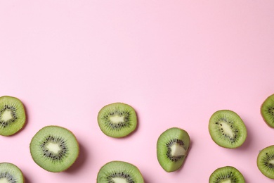 Pieces of fresh kiwis on pink background, flat lay. Space for text