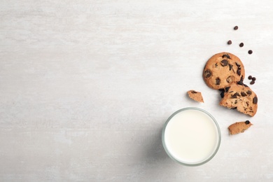 Photo of Flat lay composition with chocolate cookies and glass of milk on light background. Space for text