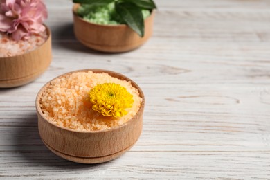 Different types of aromatic sea salt on white wooden table, closeup. Space for text