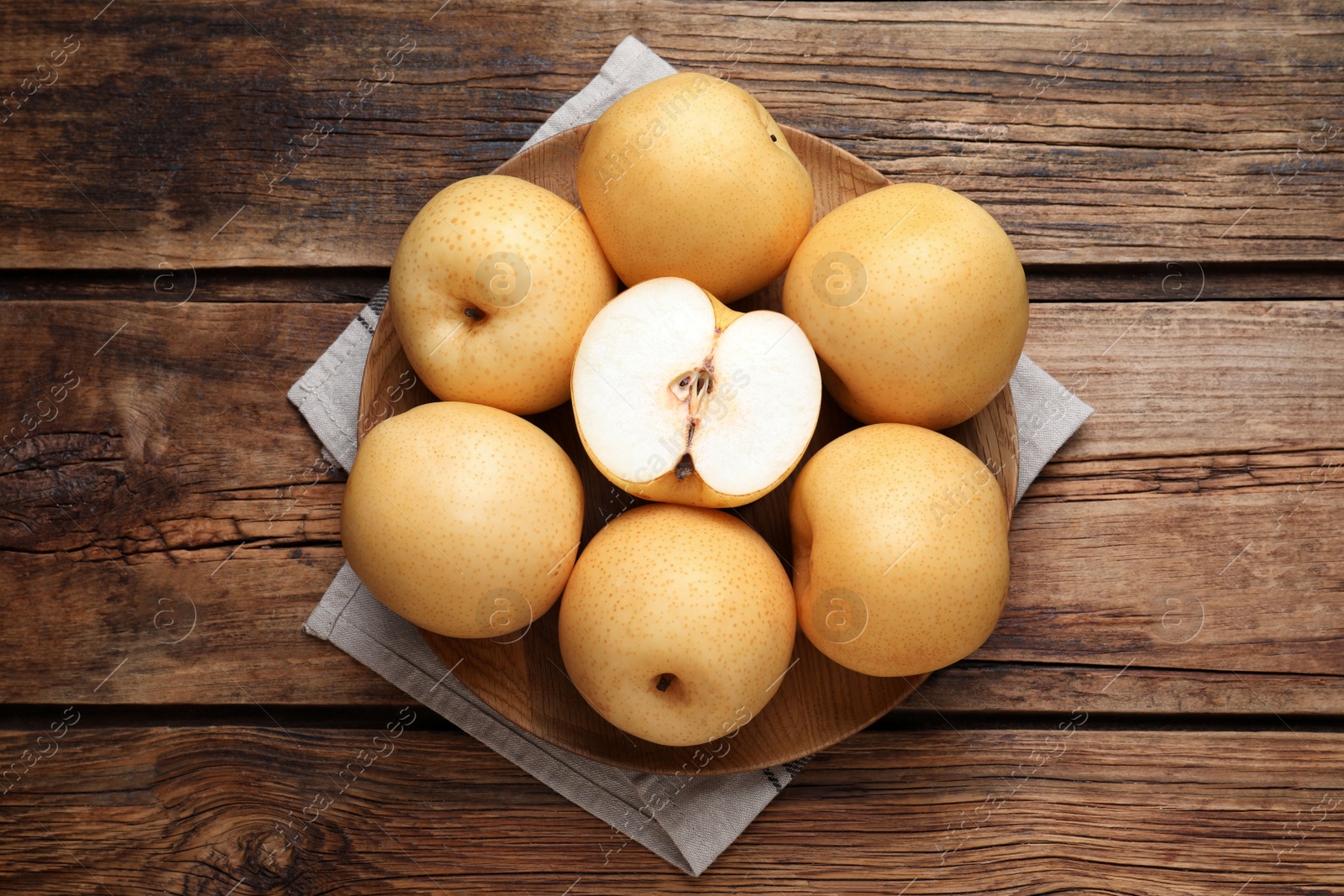 Photo of Cut and whole apple pears on wooden table, top view