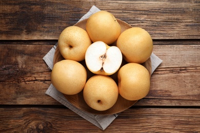 Photo of Cut and whole apple pears on wooden table, top view