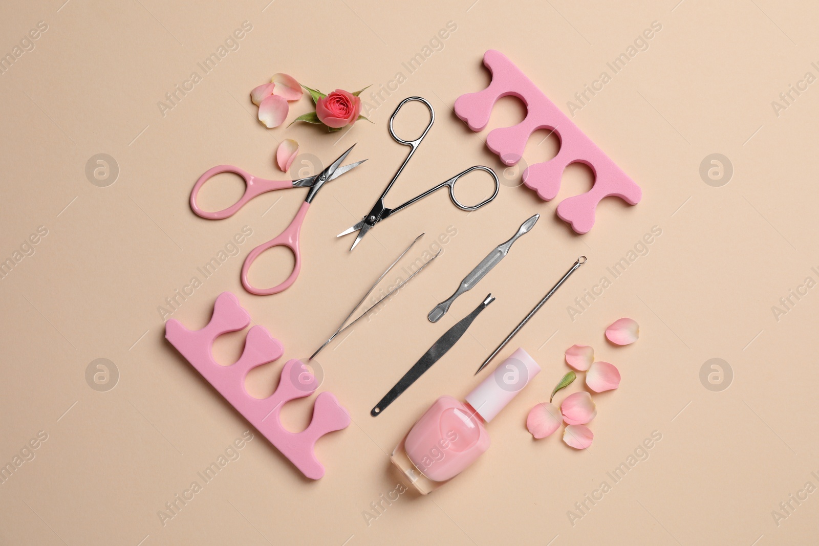 Photo of Composition with manicure and pedicure tools on beige background, flat lay