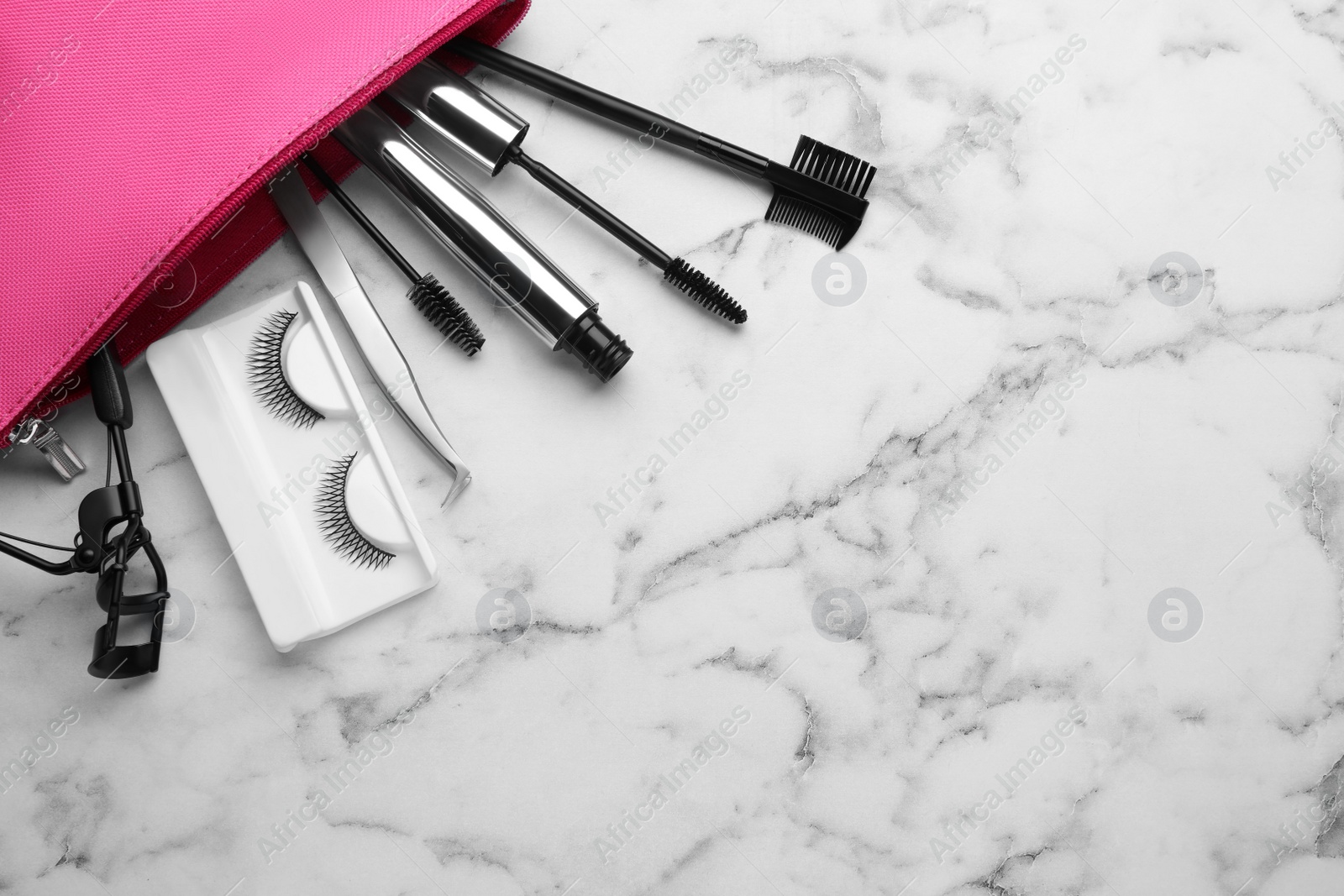 Photo of Flat lay composition with false eyelashes and tools on white marble table. Space for text