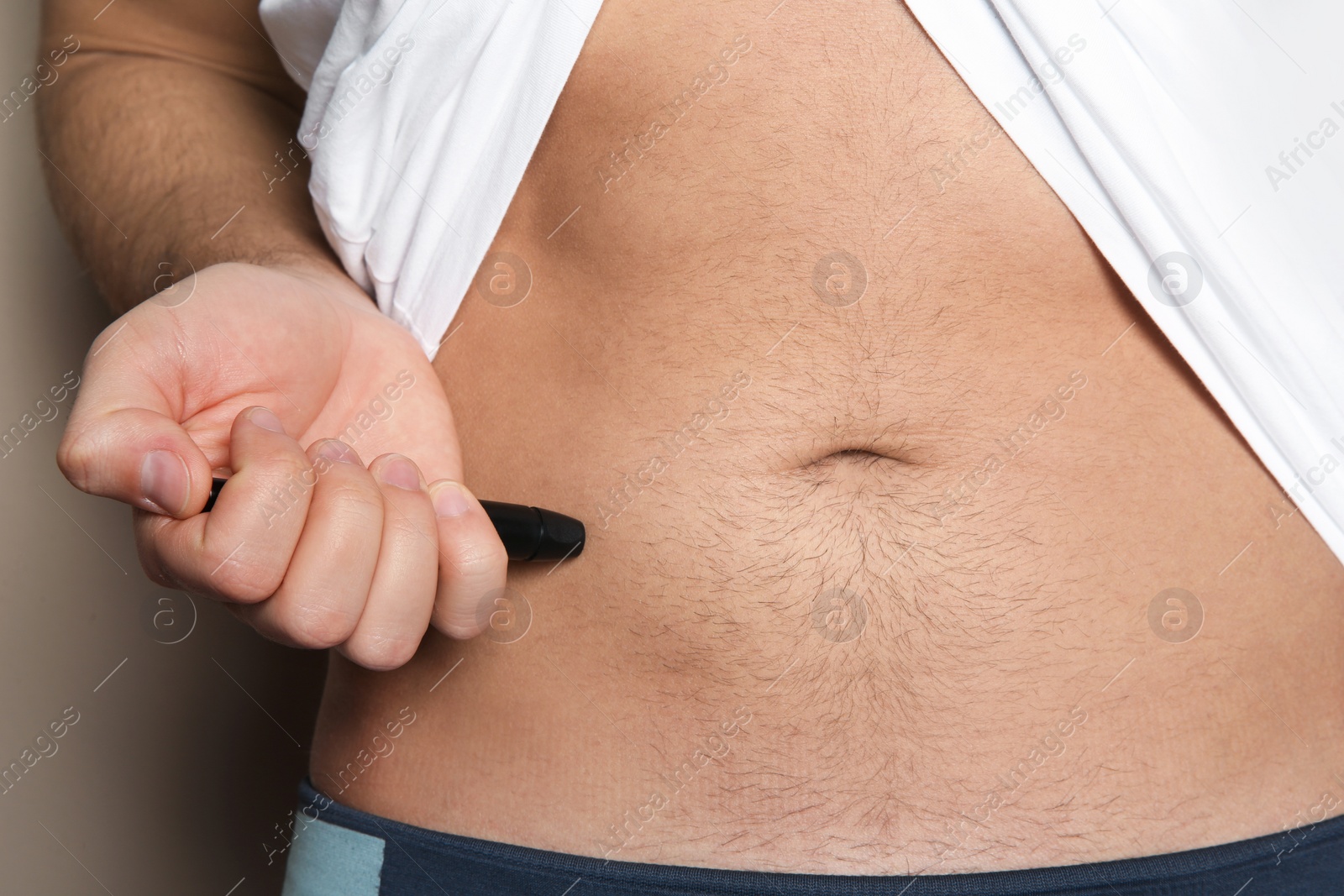 Photo of Man doing insulin injection in stomach, closeup. Diabetes disease