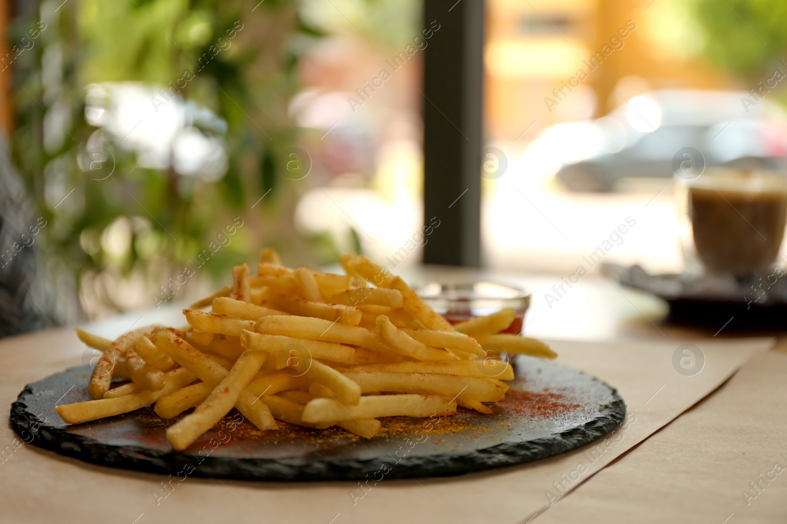 Photo of Delicious hot french fries with red sauce served on table