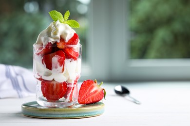 Photo of Delicious strawberries with whipped cream served on white wooden table indoors. Space for text
