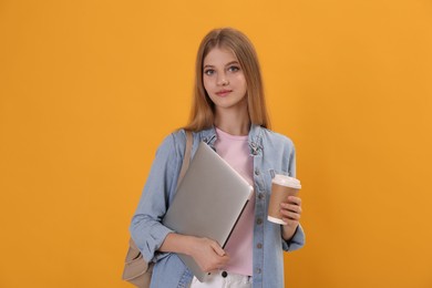Photo of Teenage student with laptop, cup of coffee and backpack on yellow background
