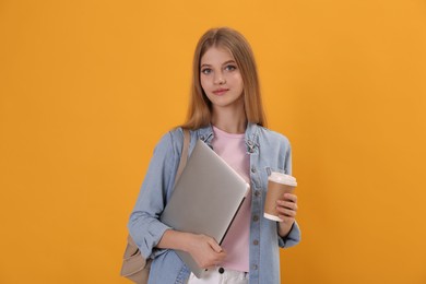 Teenage student with laptop, cup of coffee and backpack on yellow background