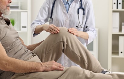 Photo of Arthritis symptoms. Doctor examining patient with knee pain in hospital