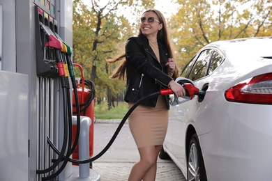 Woman refueling car at self service gas station