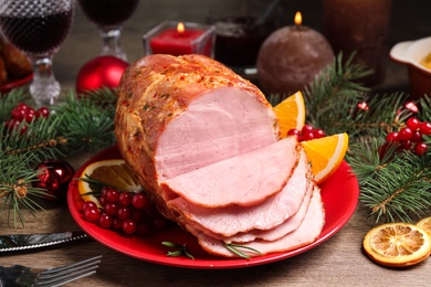 Photo of Plate with delicious ham served on wooden table. Christmas dinner