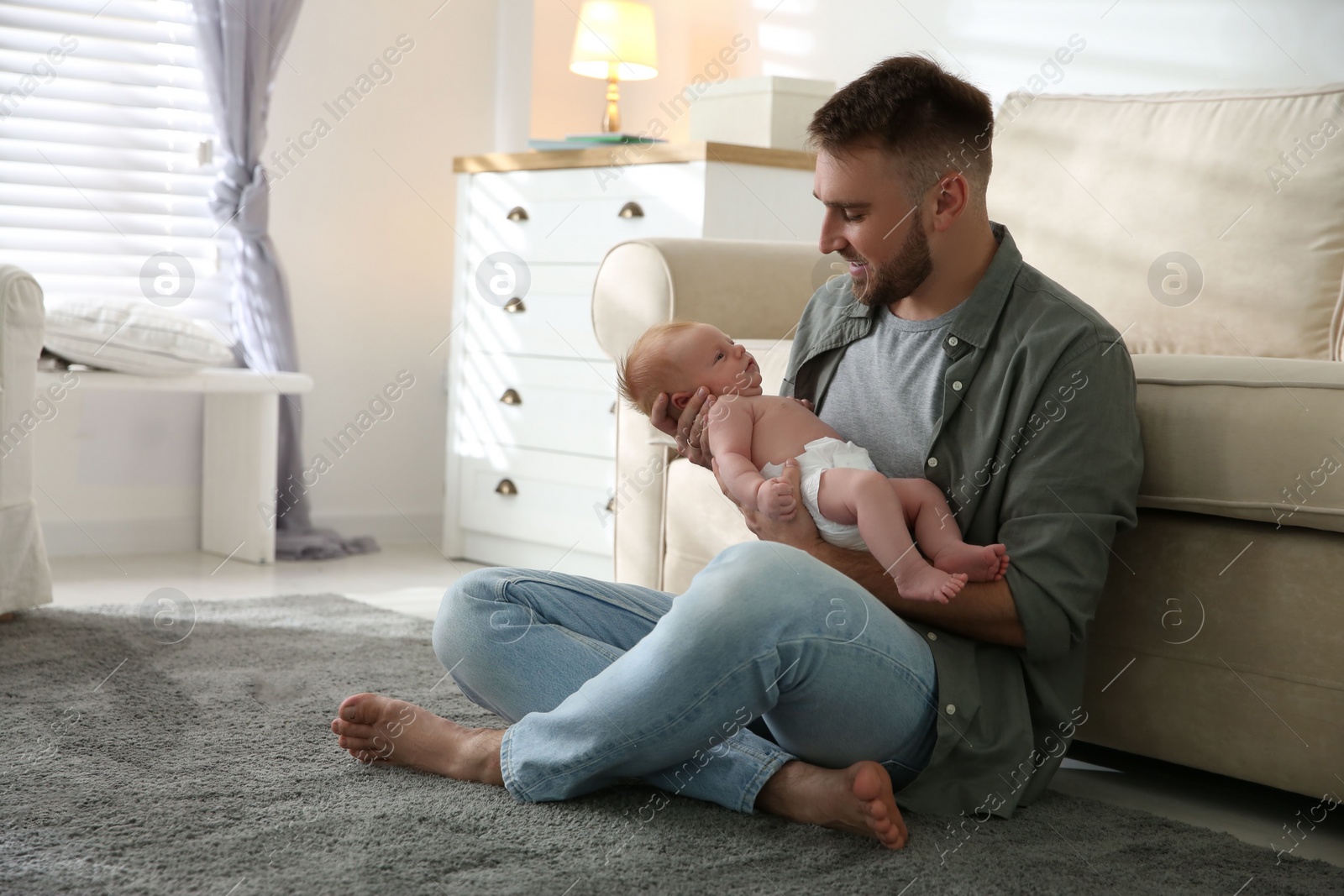 Photo of Father with his newborn son at home