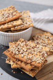 Photo of Cereal crackers with flax, sunflower and sesame seeds on table, closeup