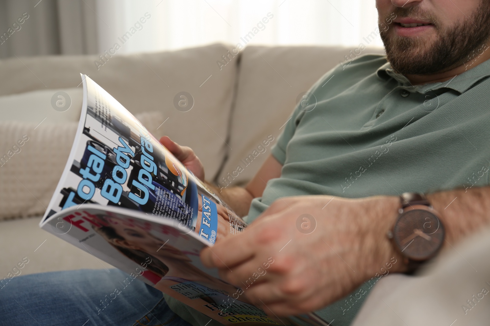 Photo of Man reading sports magazine indoors, closeup view