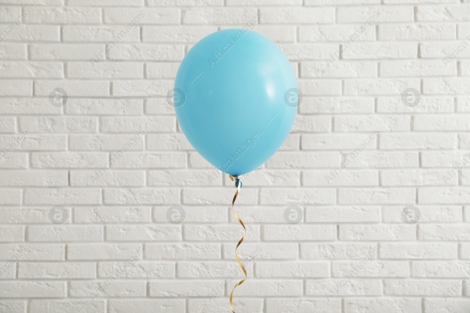 Photo of Bright balloon near brick wall. Celebration time
