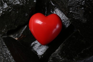 Photo of Red decorative heart on stones, top view