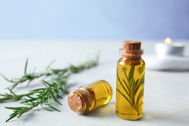 Small bottles with rosemary oil on table