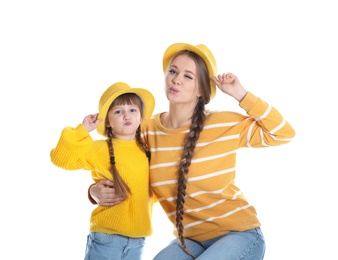 Happy woman and daughter in stylish clothes on white background