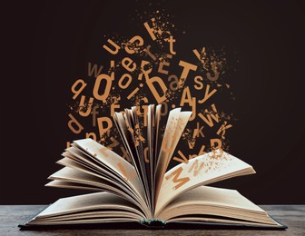 Image of Open book with flying letters on wooden table against brown background. Dyslexia concept