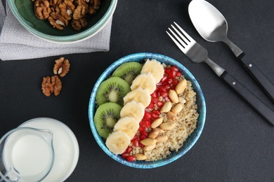 Photo of Flat lay composition with quinoa porridge and milk on black table. Tasty breakfast