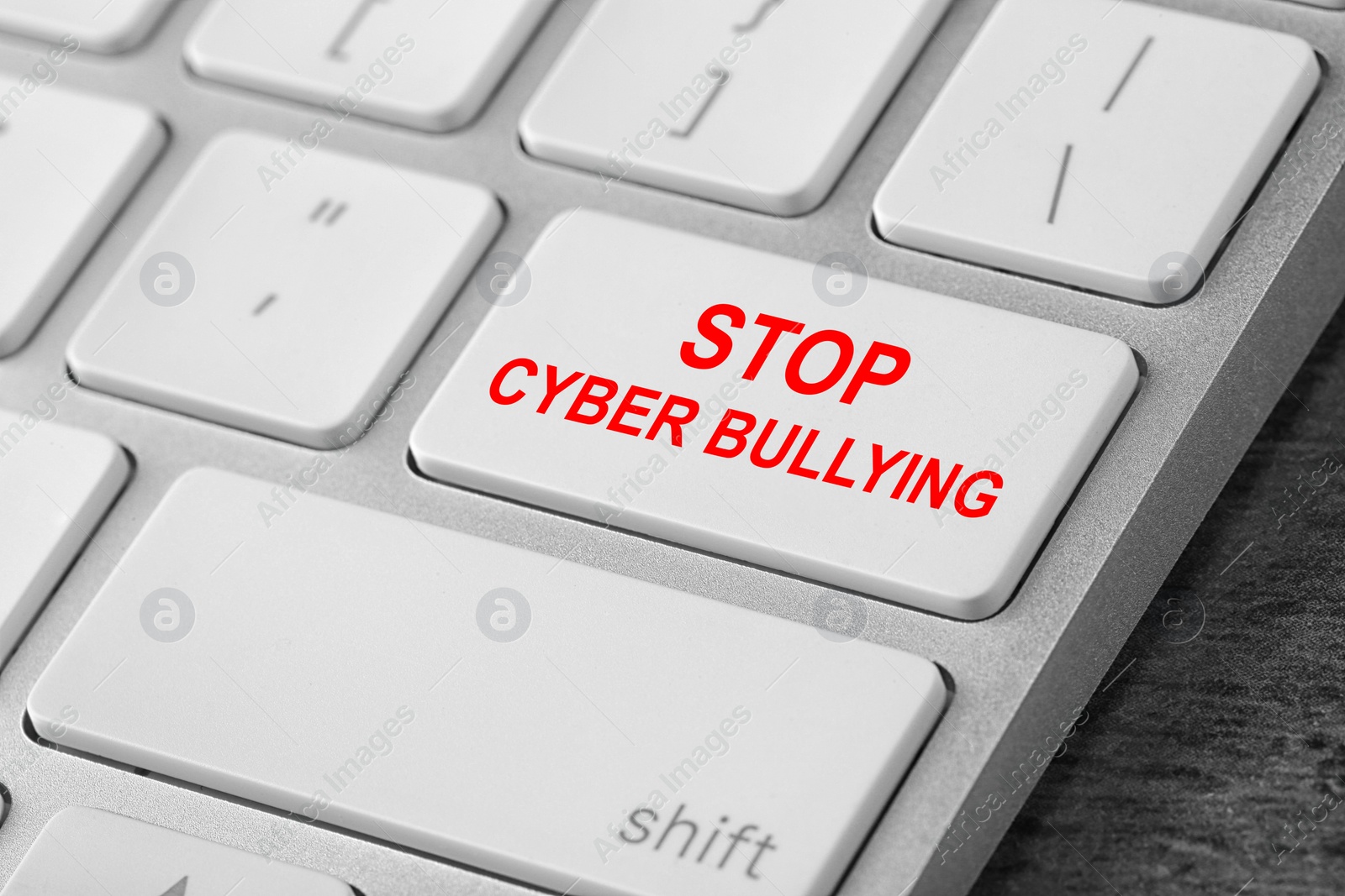 Image of Modern computer keyboard with phrase STOP CYBER BULLYING on white button, closeup