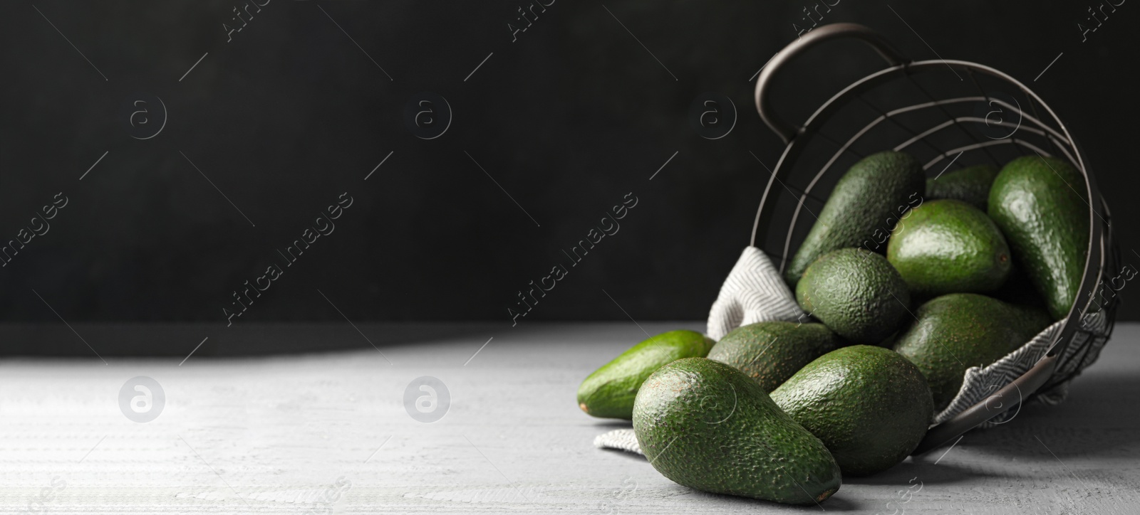 Image of Ripe avocados on table against dark background, space for text. Banner design 