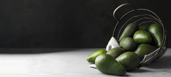 Image of Ripe avocados on table against dark background, space for text. Banner design 