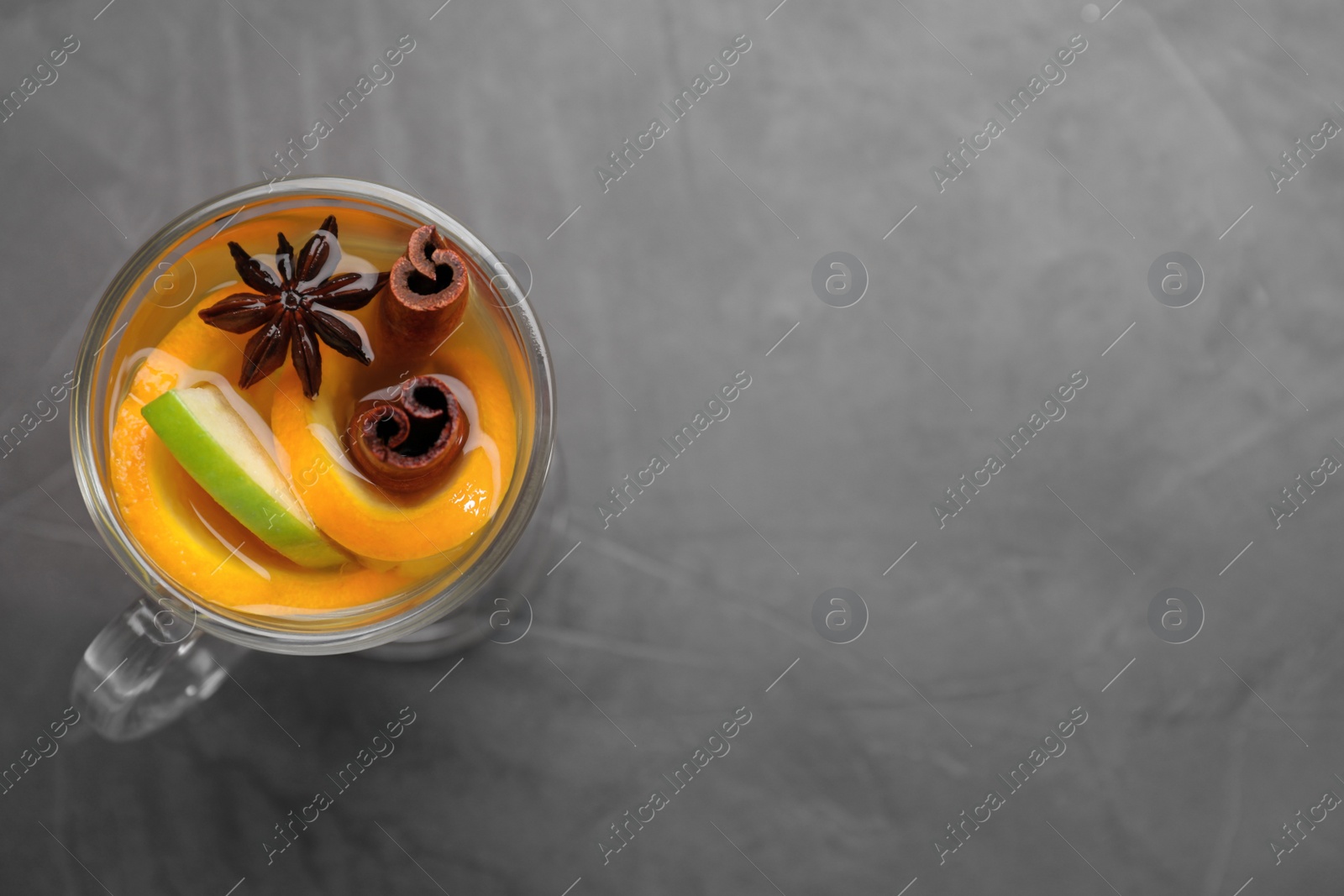 Photo of Aromatic white mulled wine on grey table, top view. Space for text